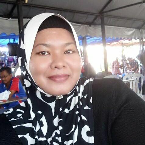 Sariah Mohdisa takes a selfie at an eatery. She is smiling and wearing a black and white patterned headscarf.
