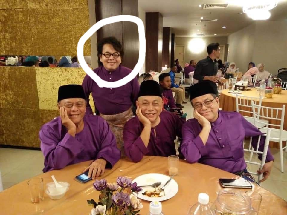 Azizi Mohd Hatta, poses with his uncles at a wedding. They are all dressed in purpose baju melayu. Azizi has floppy hair and dark-rimmed glasses. They are smiling.