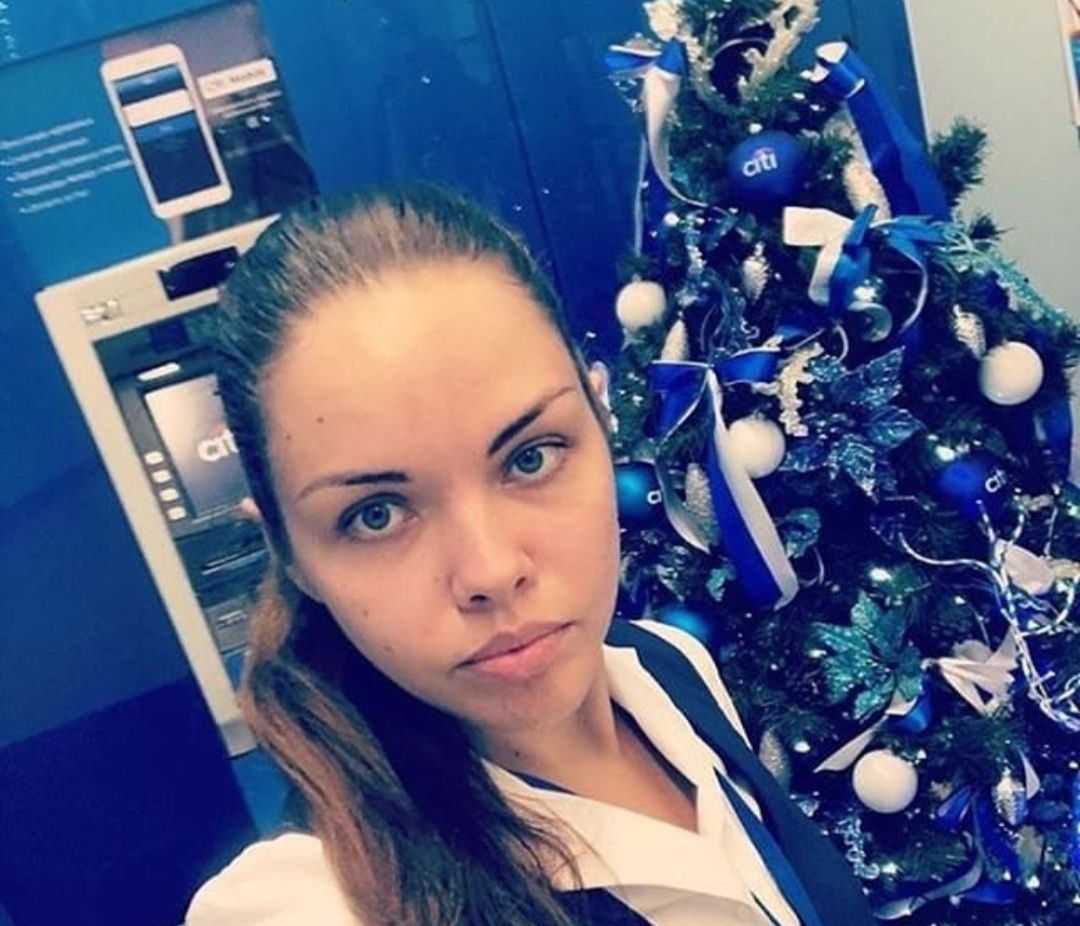 Shahidah Abdullah takes a selfie in front of a Christmas tree at Citibank. She has long hair, tied into a ponytail. 