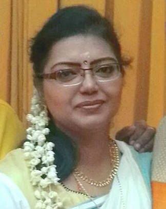 Mageswary Birabakaran, 46, smiles slightly. Se has jasmine flowers in her hair.  
