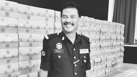 Dahalan bin Aman in a candid shot. He is smiling in his marine police uniform. He has a mustache.