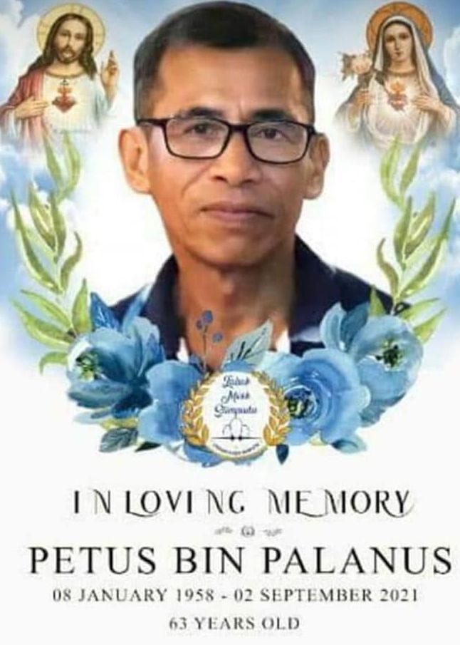 Death announcement of Petus bin Palanus, botn Jan 8, 1958 and died Sept 2, 2021 at 63 years old. Petus has short hair and dark rimmed glasses. His image is surrounded by a wreath of blue flowers, Jesus Christ and Mary Magdalene.