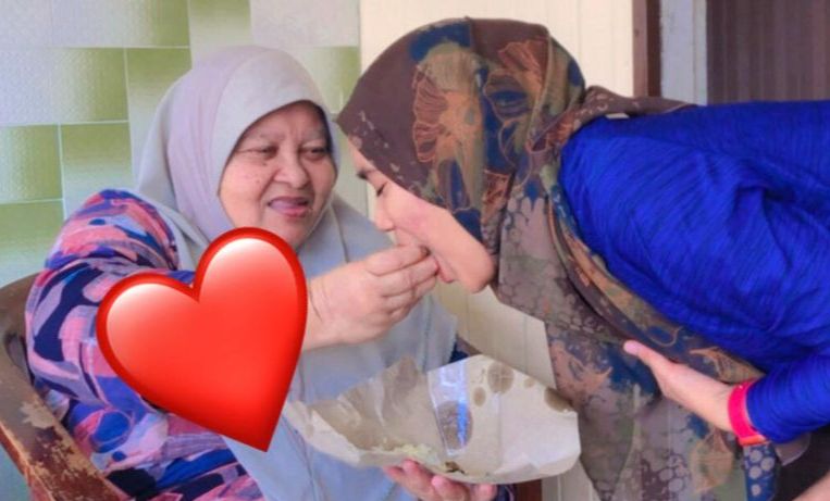 Siti Haliah Deraman handfeeds her daughter Mimi.