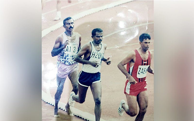 A Kandiah, runs barefoot on the bitumen track at the Merdeka Stadium during the 1977 SEA Games. He is behind two other runners, and won the bronze medal.