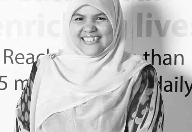 Nik Nurjihan Nik Mahayuddin looking cheerful. She is smiling widely and is dressed in a headscarf and baju kurung.